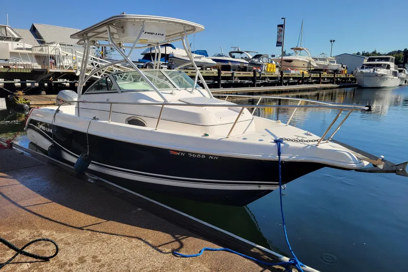 Slide: The Image of 2004 Pro-Line 23 Walk boat docked at a marina under clear blue skies. - 1