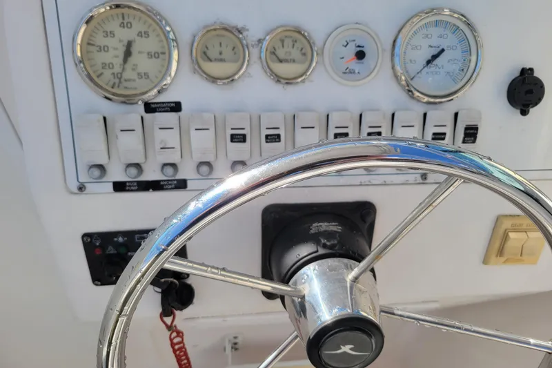Slide: The Image of 2004 Pro-Line 23 Walk boat dashboard with steering wheel and gauges. - 11