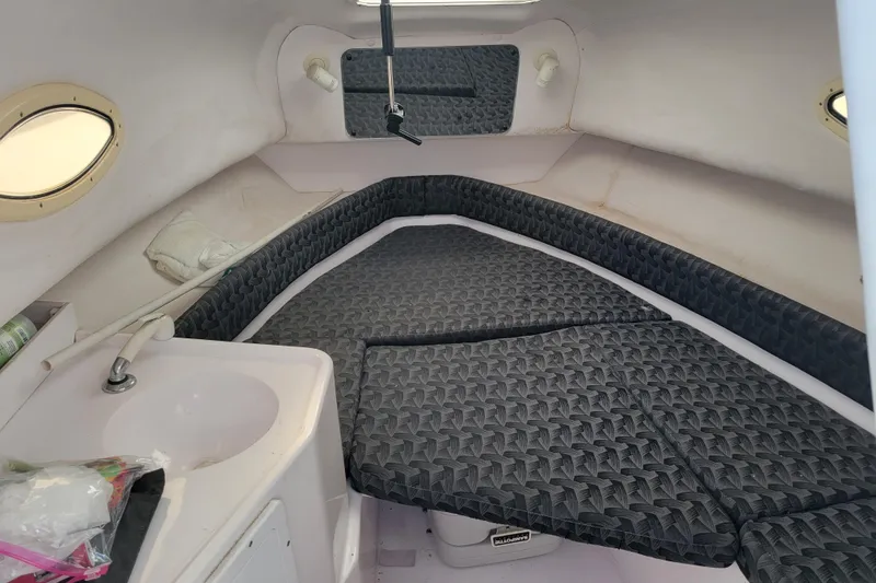 Slide: The Image of 2004 Pro-Line 23 Walk cabin interior with cushioned seating and small sink. - 12