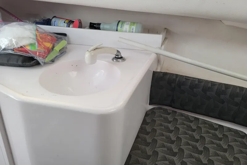 Slide: The Image of 2004 Pro-Line 23 Walk boat interior with sink and patterned seating. - 13