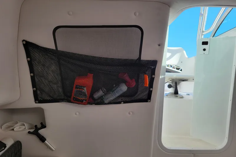 Slide: The Image of Interior of 2004 Pro-Line 23 Walk boat with storage net and visible cockpit. - 14