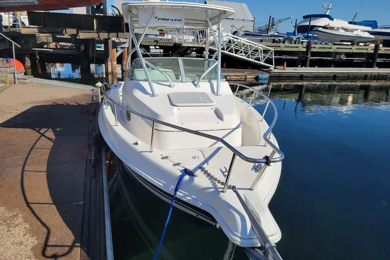 Slide: The Image of 2004 Pro-Line 23 Walk boat docked at marina, clear sunny day. - 2