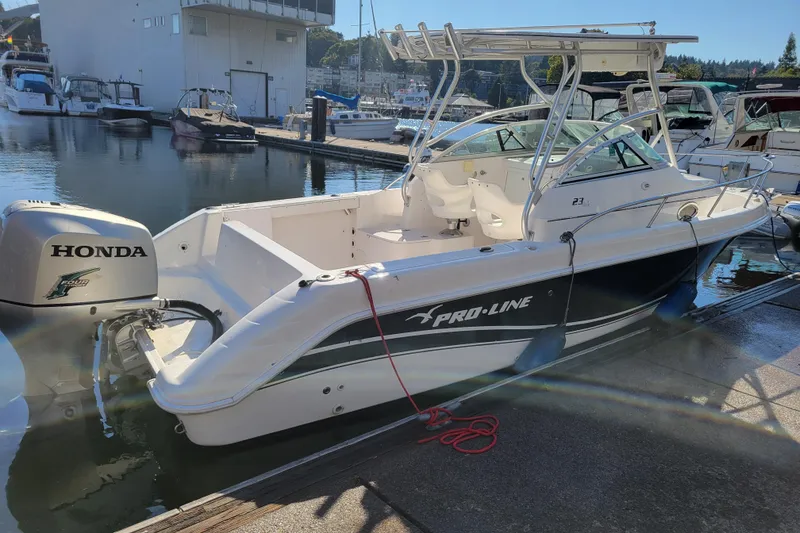 Slide: The Image of 2004 Pro-Line 23 Walk boat docked with Honda outboard motor. - 4
