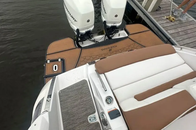 Slide: The Image of 2019 Four Winns H350 OB boat with twin outboard engines, docked on calm water. - 11