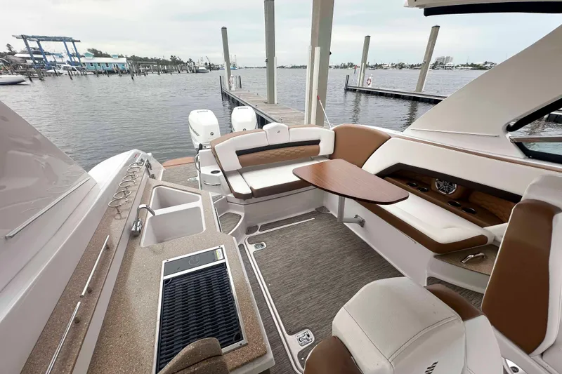 Slide: The Image of Luxurious 2019 Four Winns H350 OB boat interior with seating and table by the water. - 13