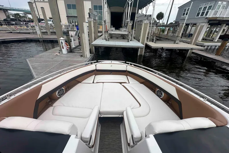 Slide: The Image of 2019 Four Winns H350 OB boat with spacious seating at a marina dock. - 17