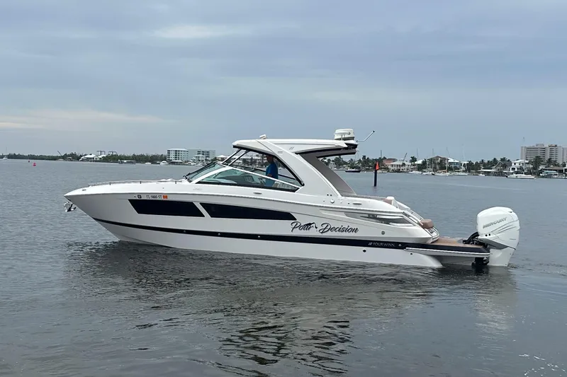 Slide: The Image of 2019 Four Winns H350 OB boat cruising on calm waters, side view. - 2