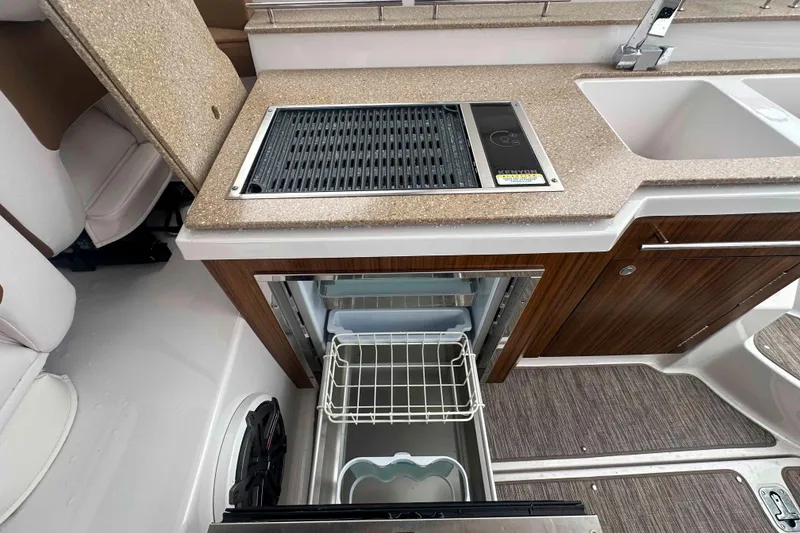 Slide: The Image of 2019 Four Winns H350 OB boat kitchen with grill, sink, and storage. - 23