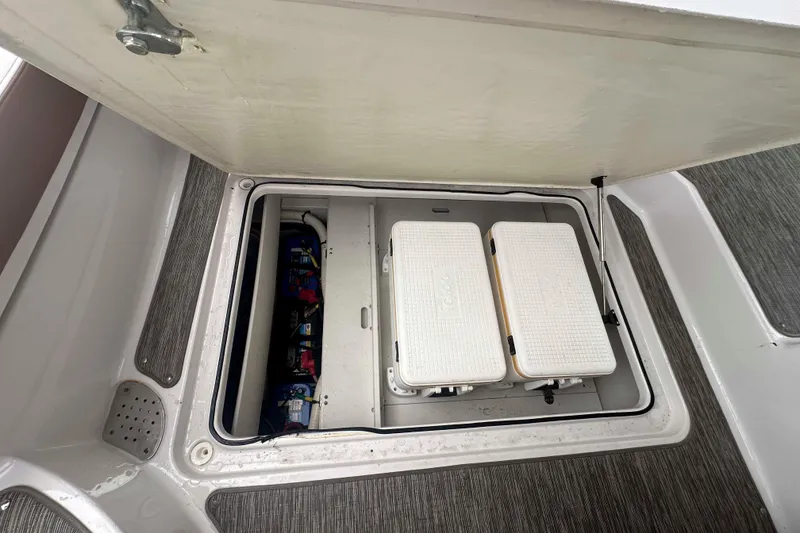 Slide: The Image of Storage compartment on a 2019 Four Winns H350 OB boat with coolers and batteries. - 24