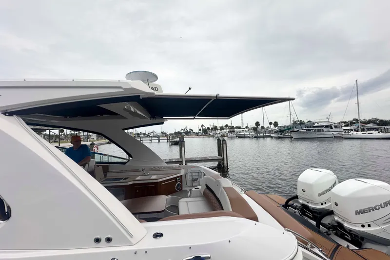 Slide: The Image of 2019 Four Winns H350 OB boat docked with dual Mercury outboard engines. - 25