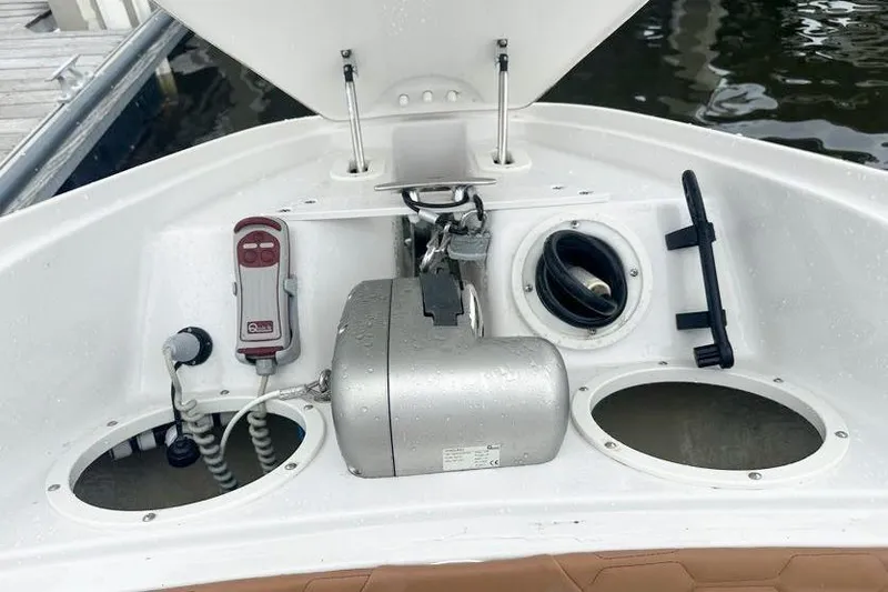 Slide: The Image of 2019 Four Winns H350 OB boat anchor compartment with winch and controls. - 29