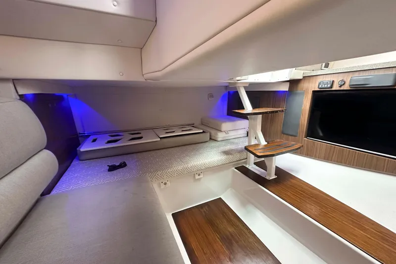 Slide: The Image of 2019 Four Winns H350 OB cabin interior with modern design, wood accents, and ambient lighting. - 30