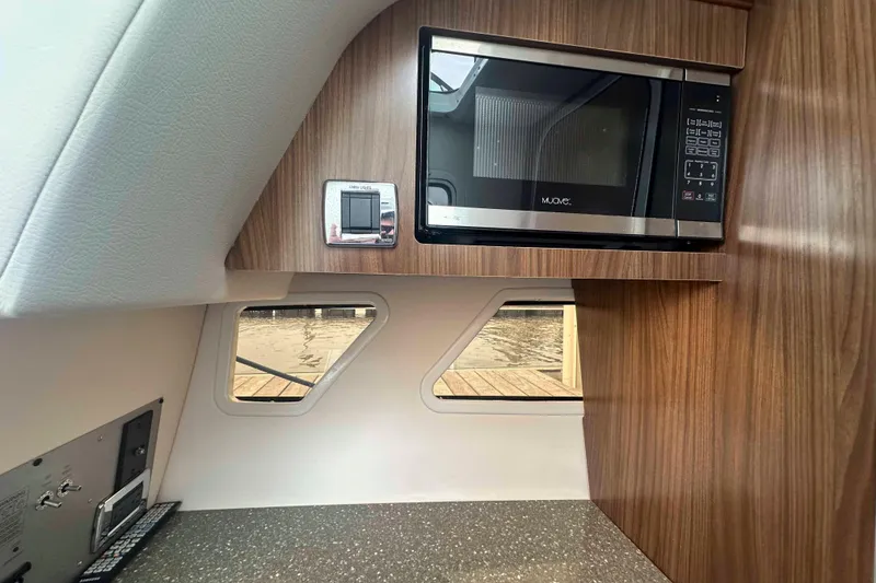 Slide: The Image of 2019 Four Winns H350 OB interior with microwave and wood paneling. - 32