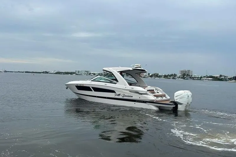 Slide: The Image of 2019 Four Winns H350 OB boat cruising on calm waters under a cloudy sky. - 6