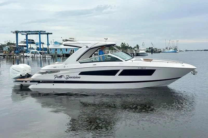 Slide: The Image of 2019 Four Winns H350 OB boat on calm water, featuring sleek design and modern outboard engines. - 7