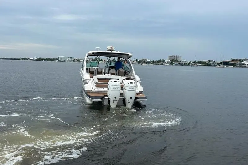 Slide: The Image of 2019 Four Winns H350 OB boat cruising on calm waters with twin engines. - 8