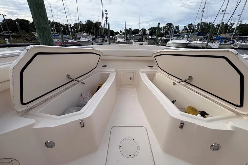 Slide: The Image of 2020 Grady-White Canyon 306 boat with open storage compartments at a marina. - 24