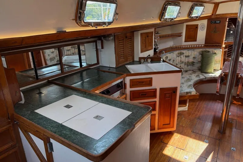 Slide: The Image of Interior of 1977 Cheoy Lee Offshore 41 ketch, featuring a cozy kitchen and seating area. - 10