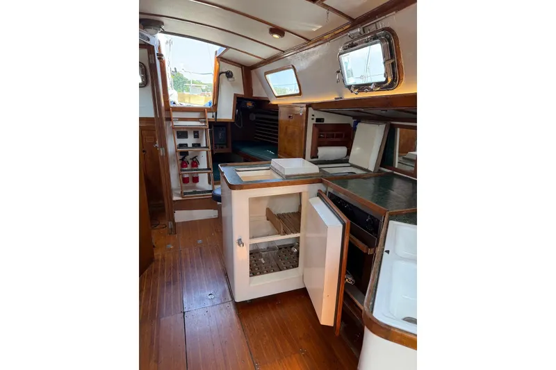 Slide: The Image of 1977 Cheoy Lee Offshore 41 ketch interior with wooden cabinetry and open storage. - 14