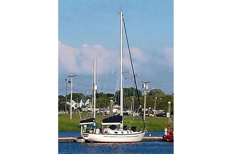 Slide: The Image of 1977 Cheoy Lee Offshore 41 ketch docked by the shore under a clear blue sky. - 2