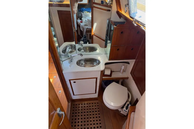 Slide: The Image of 1977 Cheoy Lee Offshore 41 ketch bathroom with dual sinks and wooden cabinetry. - 21