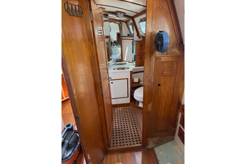 Slide: The Image of 1977 Cheoy Lee Offshore 41 ketch interior with wooden cabinetry and compact bathroom. - 9