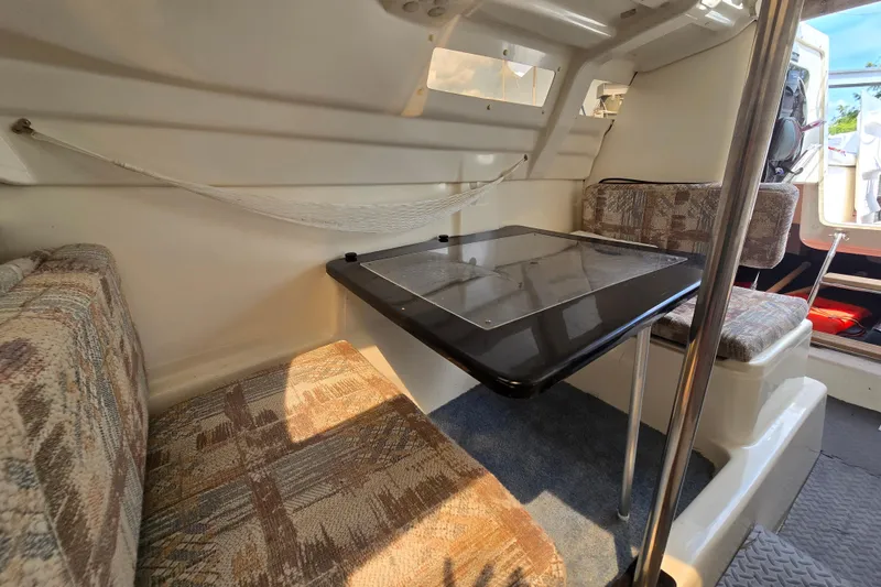 Slide: The Image of Interior of 2002 MacGregor 26X Powersailer with seating and table setup. - 13