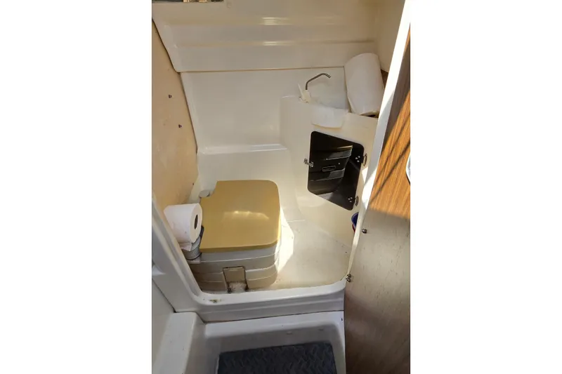 Slide: The Image of Compact bathroom in 2002 MacGregor 26X Powersailer with portable toilet and storage. - 14
