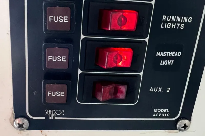Slide: The Image of Control panel of a 2002 MacGregor 26X Powersailer with switches and fuses. - 16