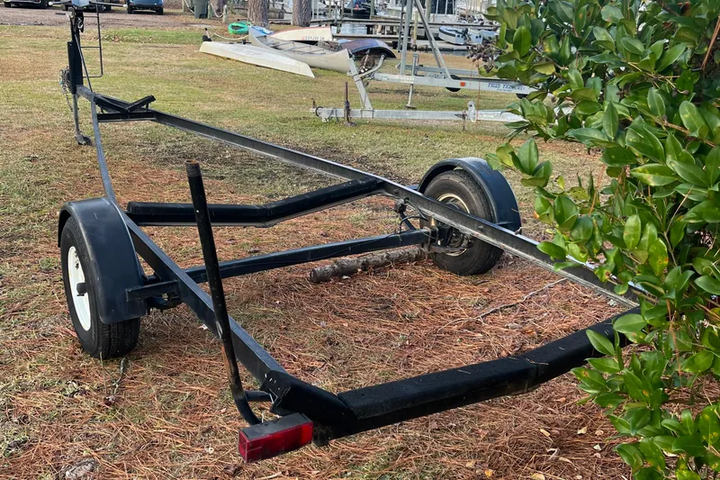 Slide: The Image of Trailer for 2002 MacGregor 26X Powersailer on grassy area near bushes. - 19