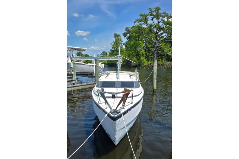Slide: The Image of 2002 MacGregor 26X Powersailer docked on a sunny day, surrounded by trees and calm water. - 3
