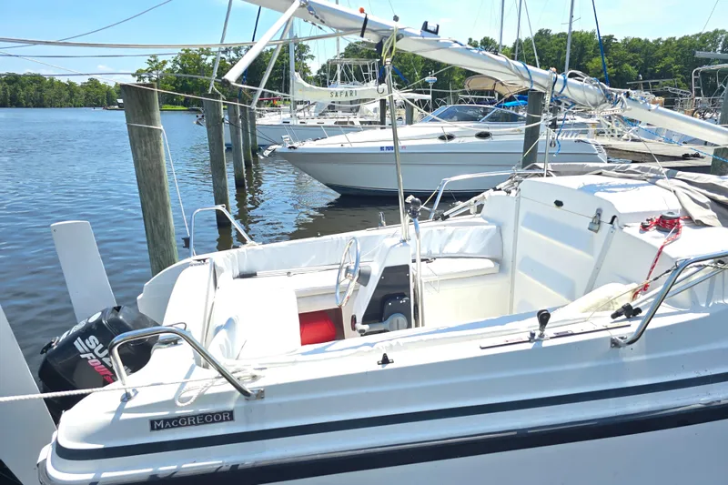 Slide: The Image of 2002 MacGregor 26X Powersailer docked at a marina, featuring a Suzuki outboard motor. - 4