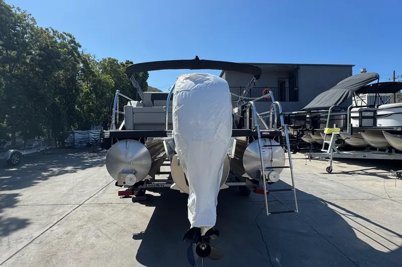 Slide: The Image of 2026 Barletta ARIA 22UC pontoon boat on trailer, covered and parked outdoors. - 10