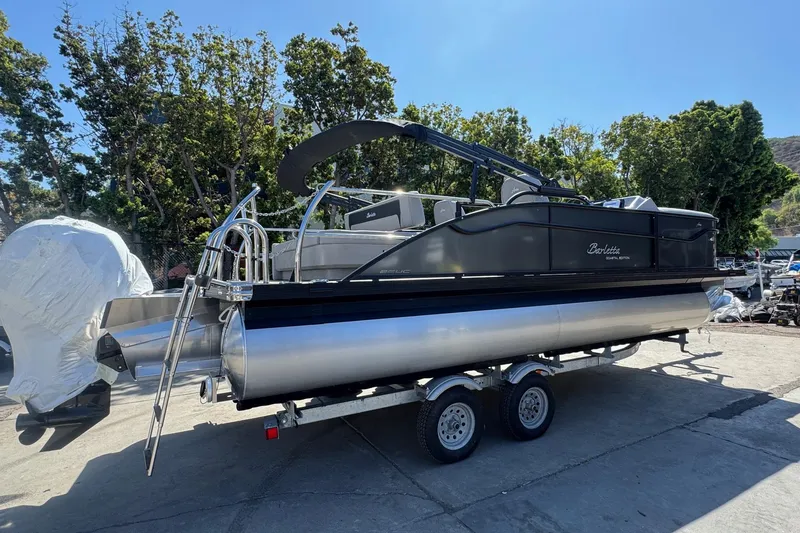 Slide: The Image of 2026 Barletta ARIA 22UC pontoon boat on trailer, parked outdoors. - 12