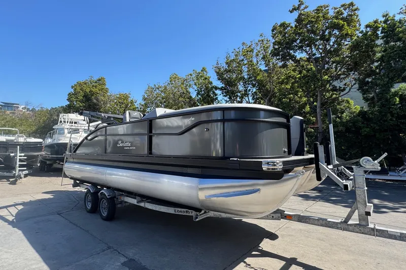 Slide: The Image of 2026 Barletta ARIA 22UC pontoon boat on trailer, parked outdoors. - 15