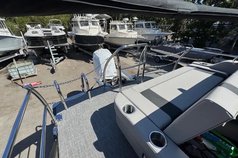 Slide: The Image of 2026 Barletta ARIA 22UC boat interior with seating, cup holders, and docked boats in background. - 59