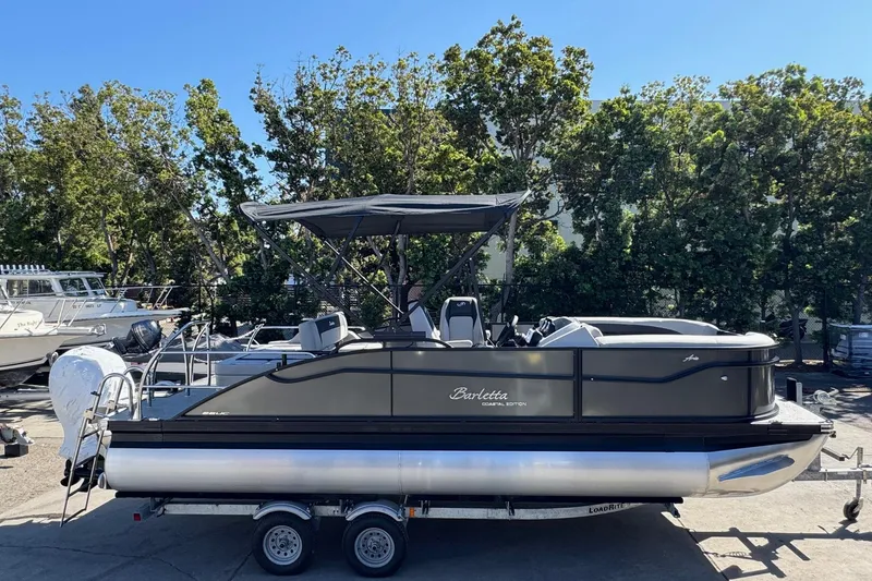 Slide: The Image of 2026 Barletta ARIA 22UC pontoon boat on trailer, parked outdoors. - 65