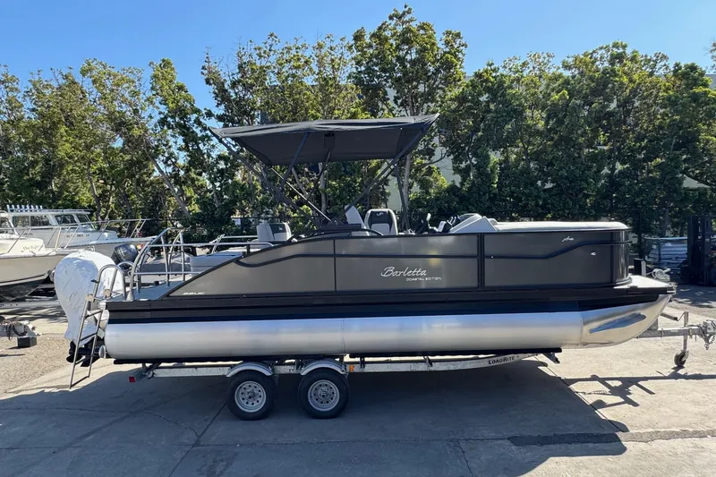 Slide: The Image of 2026 Barletta ARIA 22UC pontoon boat on trailer, parked outdoors. - 66
