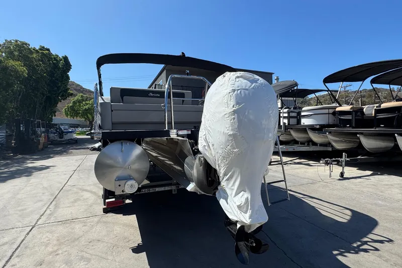 Slide: The Image of 2026 Barletta ARIA 22UC pontoon boat with covered engine, parked outdoors. - 9