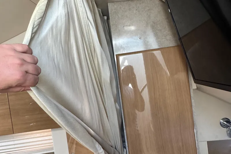 Slide: The Image of Hand pulling curtain inside 2011 Formula 37 Performance Cruiser, revealing wooden interior panel. - 24