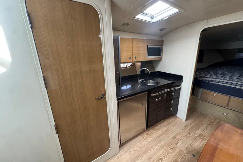 Slide: The Image of 2011 Formula 37 Performance Cruiser interior with kitchenette, wood flooring, and cozy sleeping area. - 32