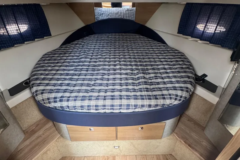 Slide: The Image of Interior cabin of 2011 Formula 37 Performance Cruiser with a plaid-patterned bed. - 37