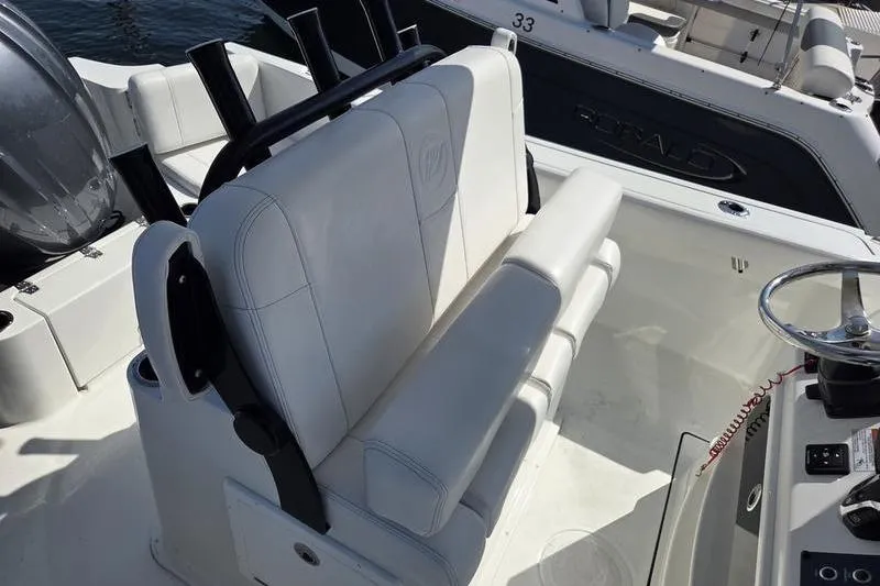 Slide: The Image of 2025 Parker 2400 Center Console boat interior with white seating and steering wheel. - 11
