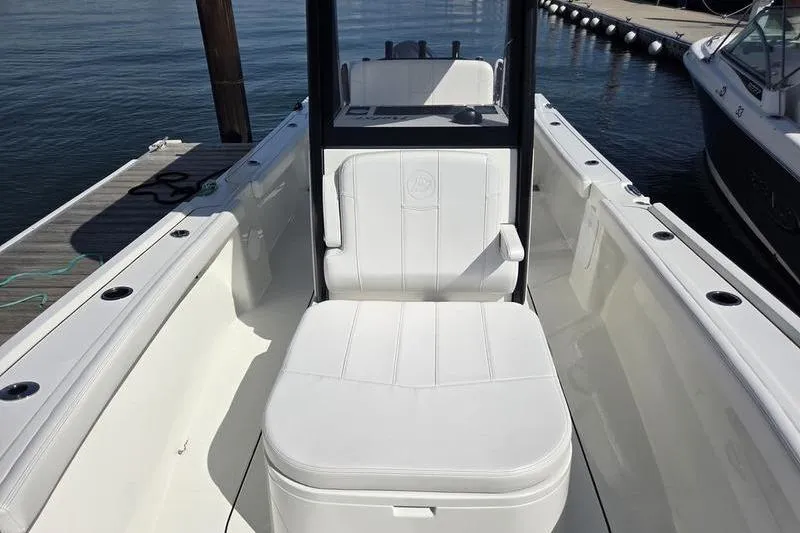 Slide: The Image of 2025 Parker 2400 Center Console boat with white seating, docked by the water. - 15