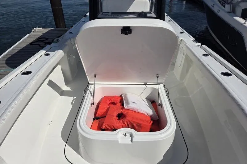 Slide: The Image of 2025 Parker 2400 Center Console boat with open storage compartment containing life jackets. - 16
