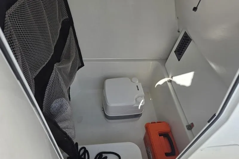 Slide: The Image of 2025 Parker 2400 Center Console interior with portable toilet and storage compartment. - 3