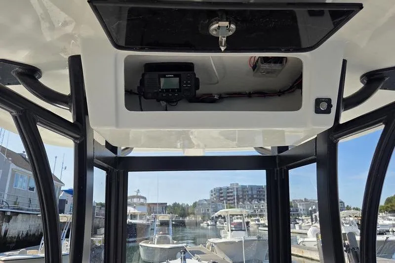 Slide: The Image of 2025 Parker 2400 Center Console boat interior with electronic equipment, docked at marina. - 7