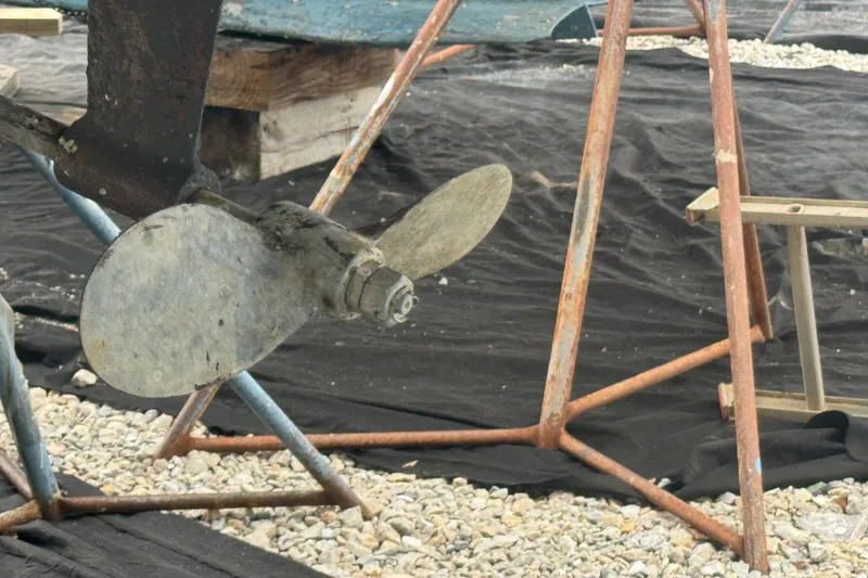 Slide: The Image of Propeller of a 1998 Hunter 376 sailboat on a stand, surrounded by gravel. - 37