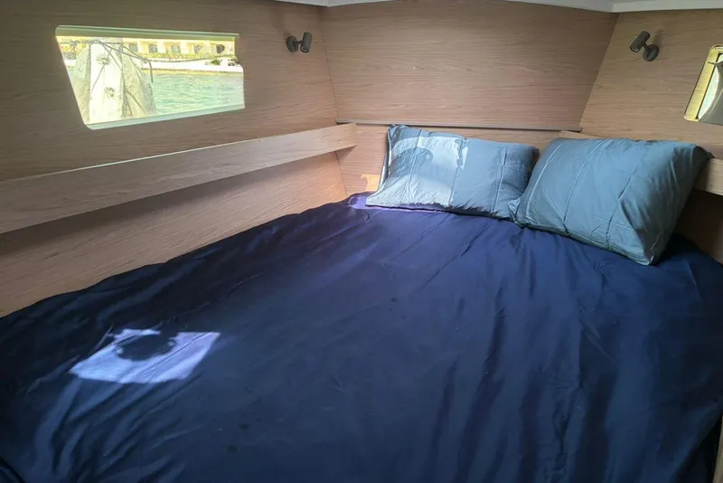 Slide: The Image of Cozy cabin interior of 2020 Beneteau Oceanis 41.1 with blue bedding and window view. - 12