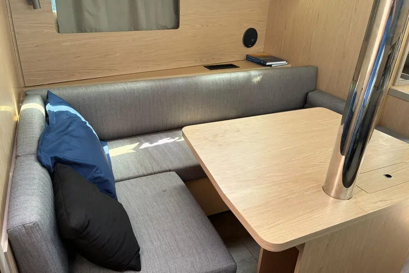 Slide: The Image of Interior of 2020 Beneteau Oceanis 41.1 yacht with cozy seating and wooden table. - 13